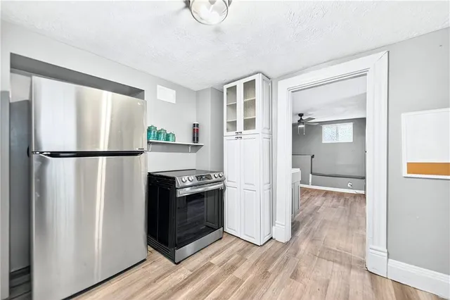 a kitchen with granite countertop a refrigerator and a stove top oven