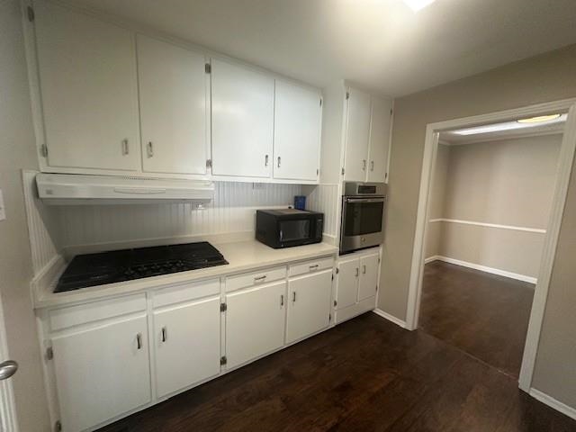 4416 Boyce Road Memphis, TN 38117 - Photo 14 of 22 Kitchen with light countertops, dark wood-type flooring, white cabinetry, black appliances, and under cabinet range hood