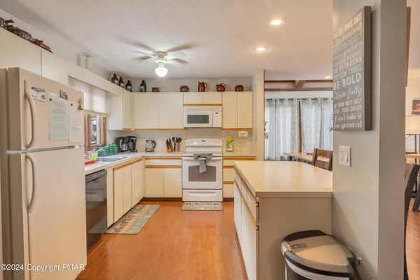 a dining room with a table chairs and potted plants