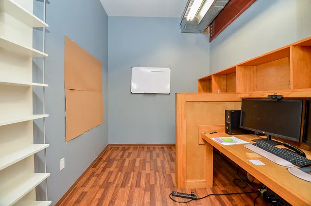 a view of workspace with wooden floor windows