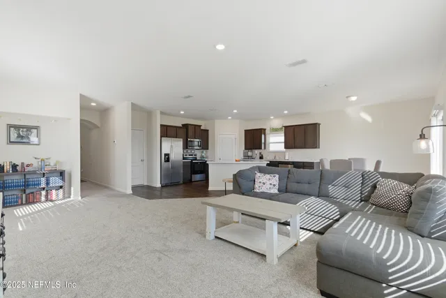 a living room with furniture and kitchen view