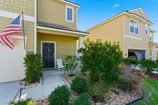 a front view of a house with plants and entryway
