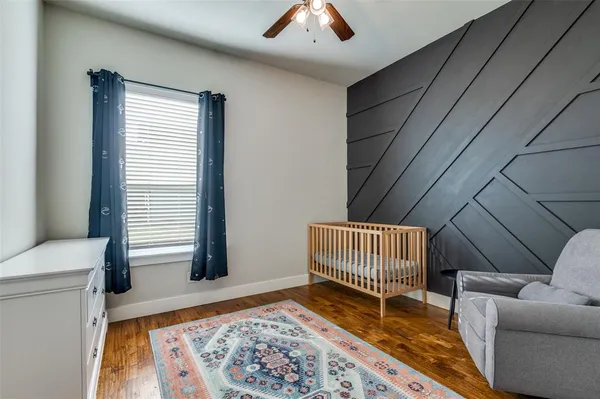 a view of a bedroom with wooden floor and a window