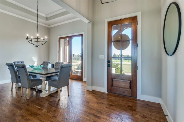 a view of a dining room with furniture a chandelier and wooden floor