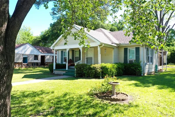 a front view of a house with a yard table and chairs