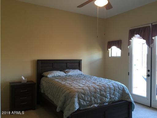 Undisclosed Address Gold Canyon, AZ 85118 - Photo 26 of 45 a bedroom with a bed and a chandelier