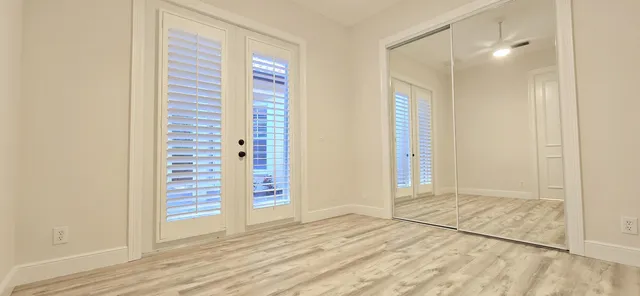 a view of an empty room with stairs and wooden floor