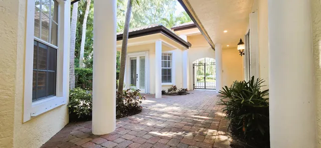 a view of an empty room with cabinet and mirrors