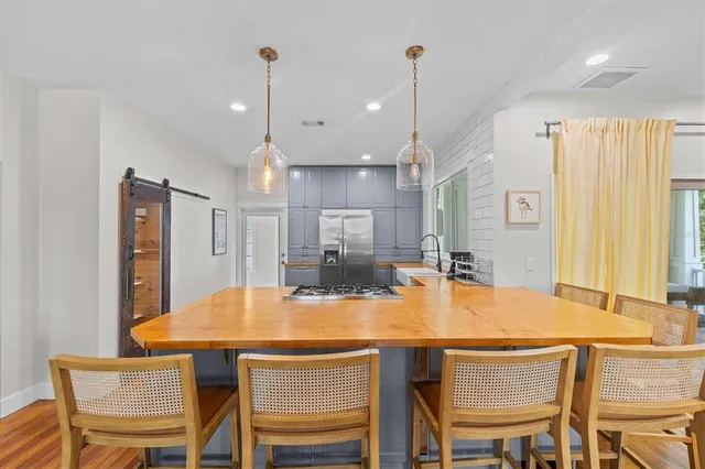 a kitchen with stainless steel appliances granite countertop a kitchen island a table and chairs