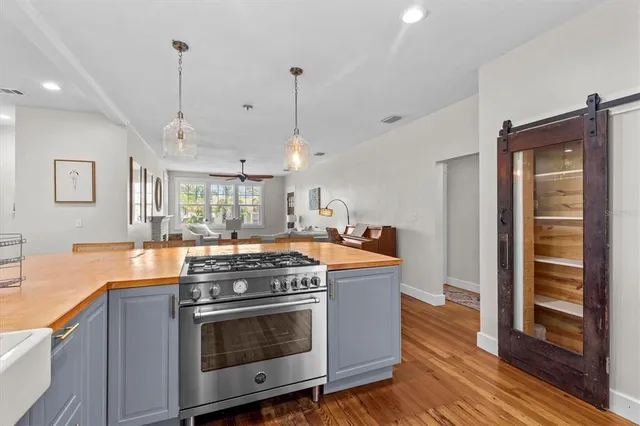 a kitchen with stove and wooden floor