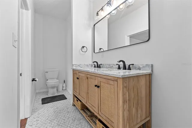 a spacious bathroom with a double vanity sink mirror and toilet