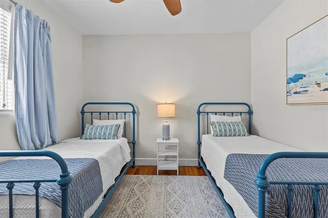 a bedroom with two beds and painting on the wall