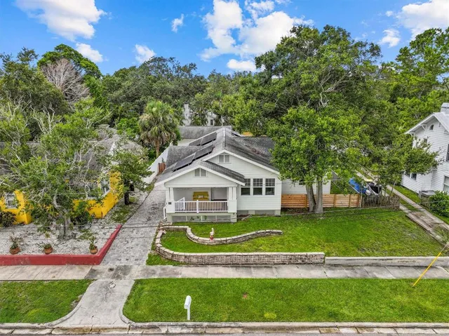 a view of a house with a big yard and large trees