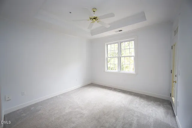 an empty room with a window and a ceiling fan