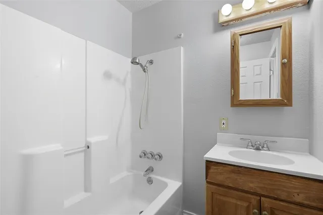 a bathroom with a sink vanity tub and shower