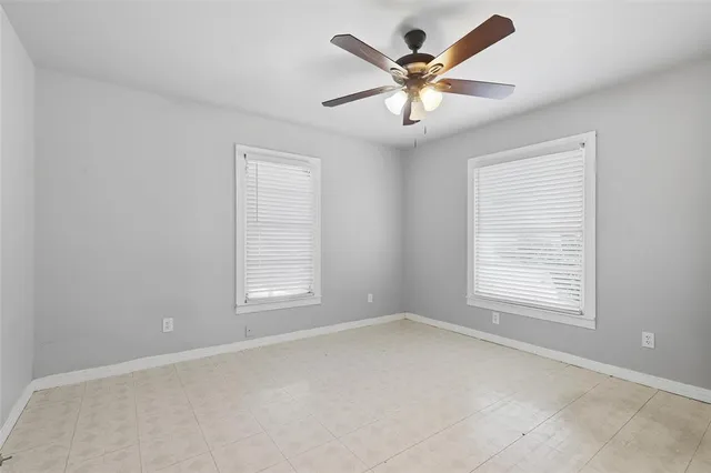 an empty room with a window and a fan