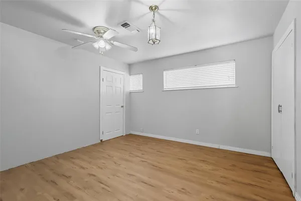 a view of empty room with wooden floor