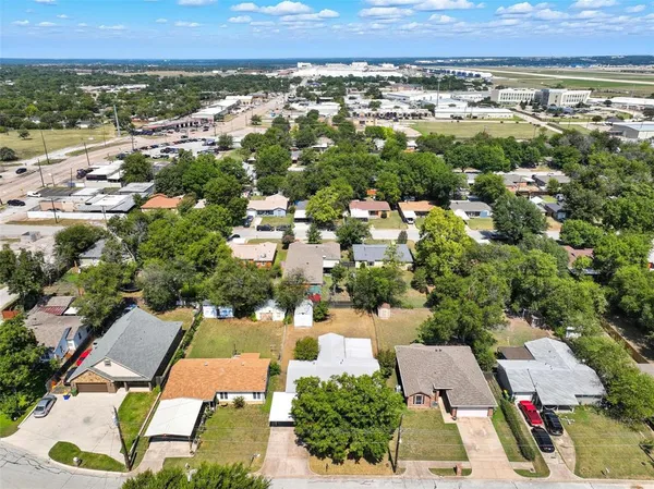 an aerial view of residential houses with outdoor space and trees