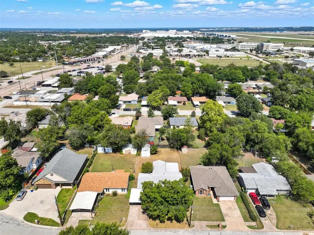 an aerial view of residential houses with outdoor space and trees