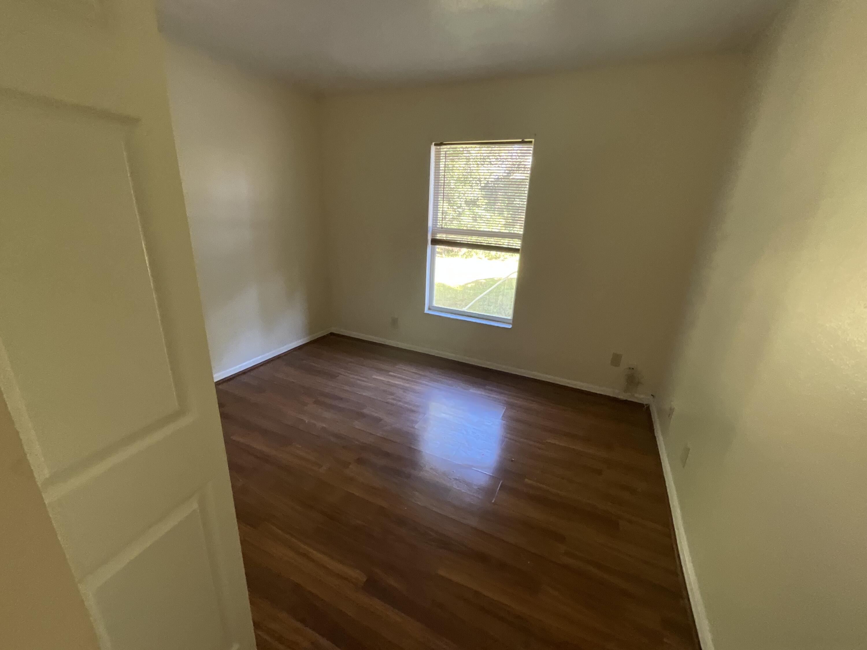1931 Southwest Fears Avenue Port St. Lucie, FL 34953 - Photo 11 of 13 an empty room with wooden floor and windows