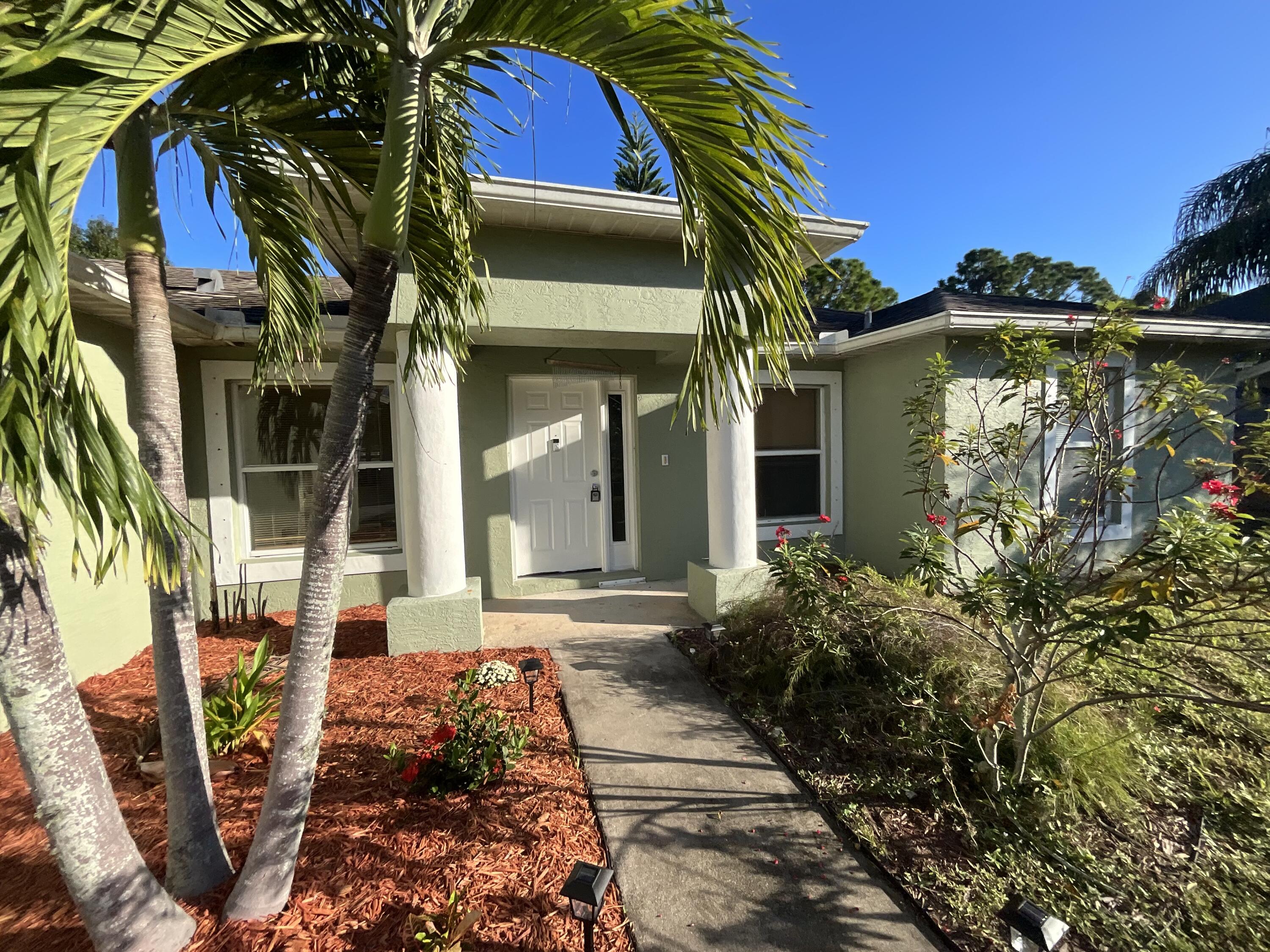 1931 Southwest Fears Avenue Port St. Lucie, FL 34953 - Photo 2 of 13 a front view of a house with a yard