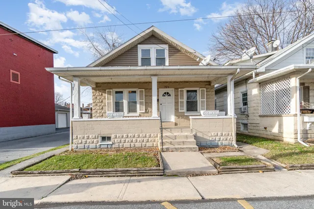 a front view of a house with a yard and potted plants