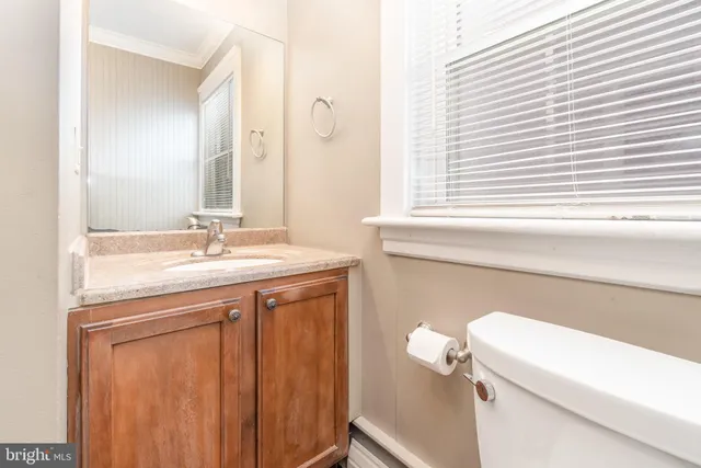 a bathroom with a sink a toilet and a window