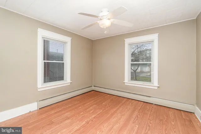 an empty room with a window and a ceiling fan