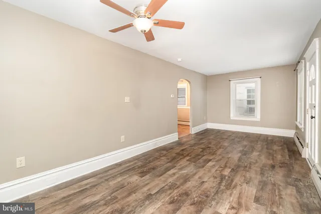 an empty room with windows and fan