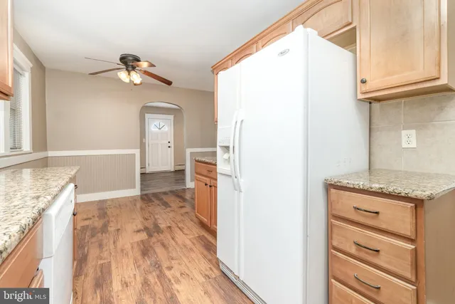 a view of kitchen with granite countertop cabinets and wooden floor