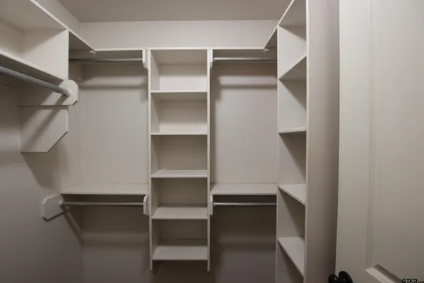 an empty room with closet and a chandelier fan