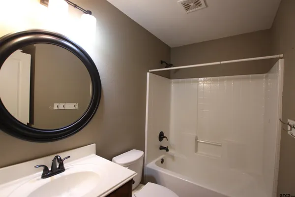 a view of an empty room and closet area with a fan