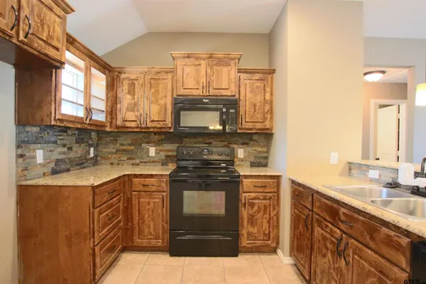 a kitchen with stainless steel appliances granite countertop a stove a sink and a microwave