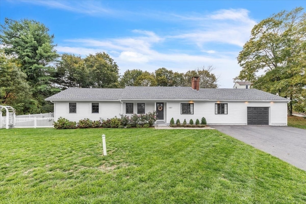 a view of a house with a big yard and large trees