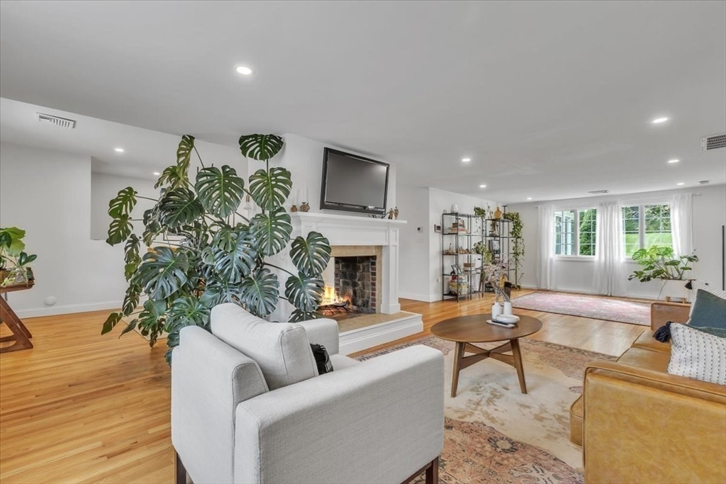 1057 Whitman Street Hanson, MA 02341 - Photo 15 of 40 a living room with furniture a large window and a fireplace