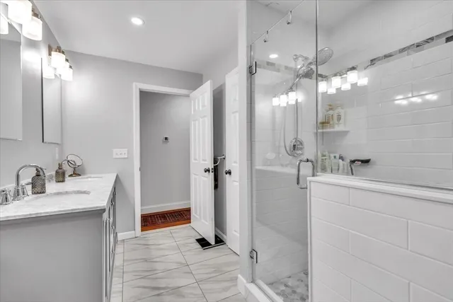 a bathroom with a double vanity sink mirror and shower
