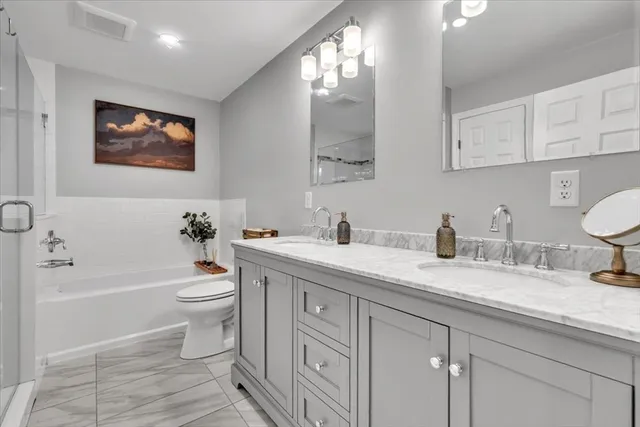 a spacious bathroom with a granite countertop toilet sink and a bathtub