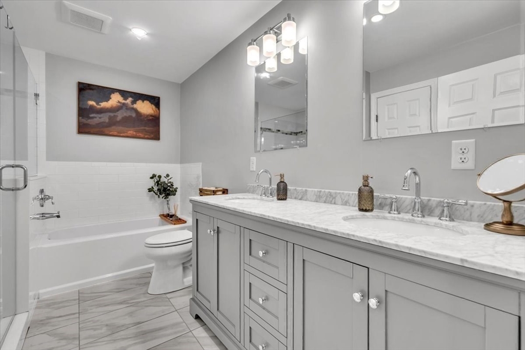 1057 Whitman Street Hanson, MA 02341 - Photo 21 of 40 a spacious bathroom with a granite countertop toilet sink and a bathtub