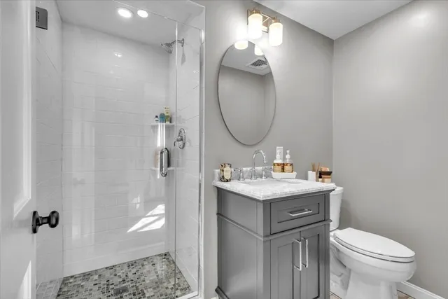 a bathroom with a granite countertop sink a toilet and shower