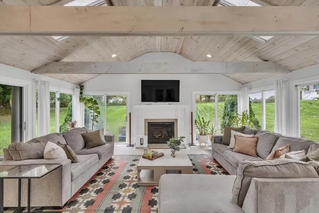 a living room with furniture a fireplace and a flat screen tv