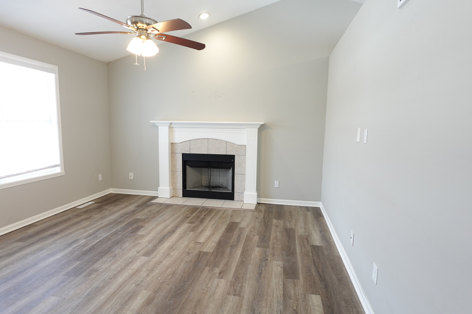 2140 Maxine Lane Rockford, IL 61102 - Photo 4 of 23 an empty room with windows fireplace and fan