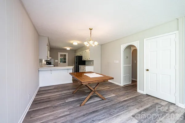 a view of a livingroom with a fireplace a ceiling fan and windows