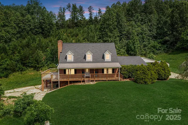 a view of a house with a big yard and large trees