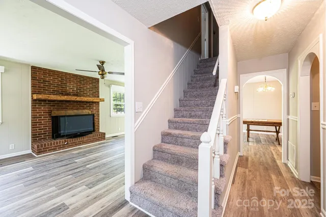 a view of a livingroom with wooden floor and a fireplace