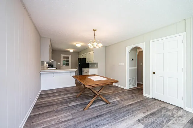 a view of a livingroom with a fireplace a ceiling fan and windows