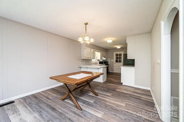 an empty room with wooden floor a ceiling fan and windows