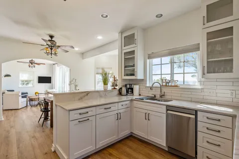 a kitchen with a sink dishwasher stove and cabinets