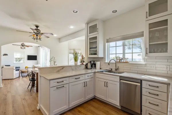 a kitchen with a sink dishwasher stove and cabinets