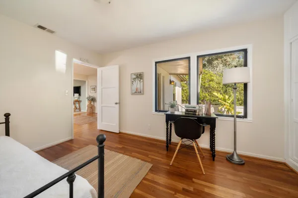 a view of a room with a table chair and wooden floor