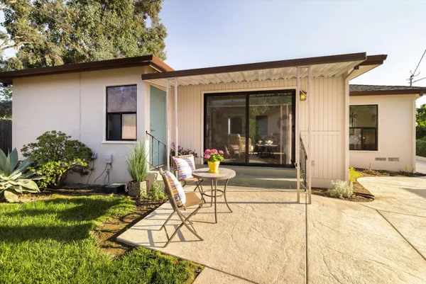 a view of a house with backyard and sitting area